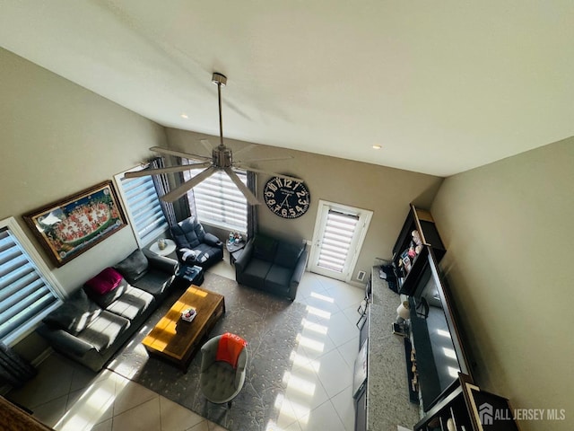 living room featuring ceiling fan, lofted ceiling, and tile patterned flooring