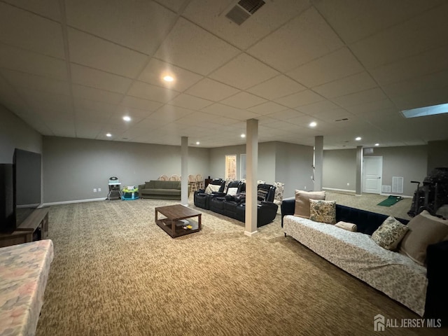 carpeted living room with baseboards, a drop ceiling, and visible vents