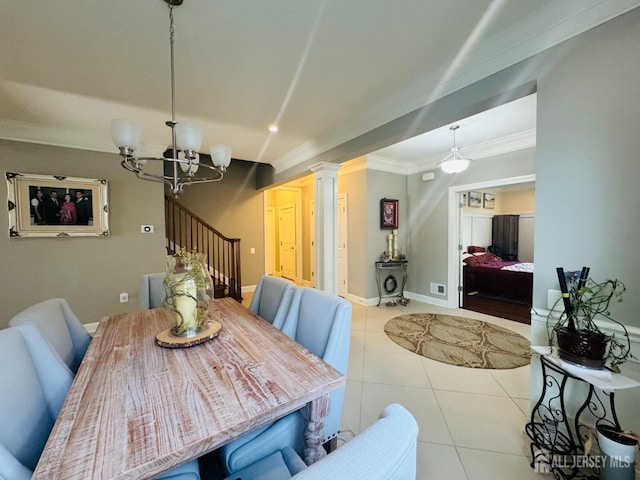 dining room featuring an inviting chandelier, ornamental molding, stairs, light tile patterned flooring, and ornate columns
