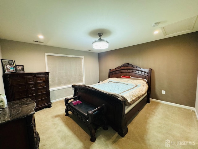 bedroom with visible vents, attic access, baseboards, and light carpet