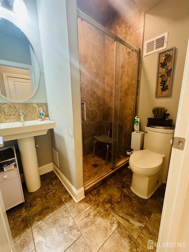 bathroom featuring visible vents, baseboards, a stall shower, and toilet