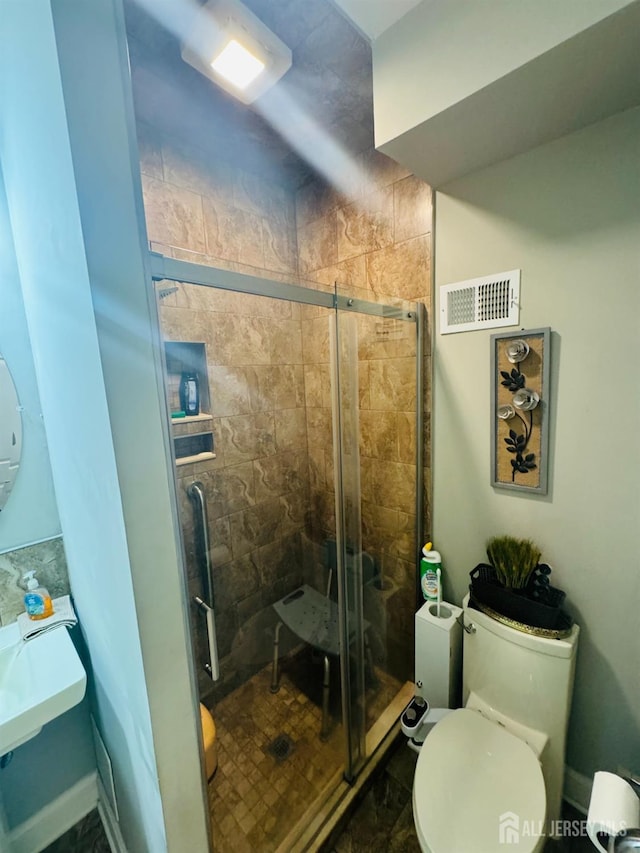 bathroom featuring visible vents, toilet, and a shower stall