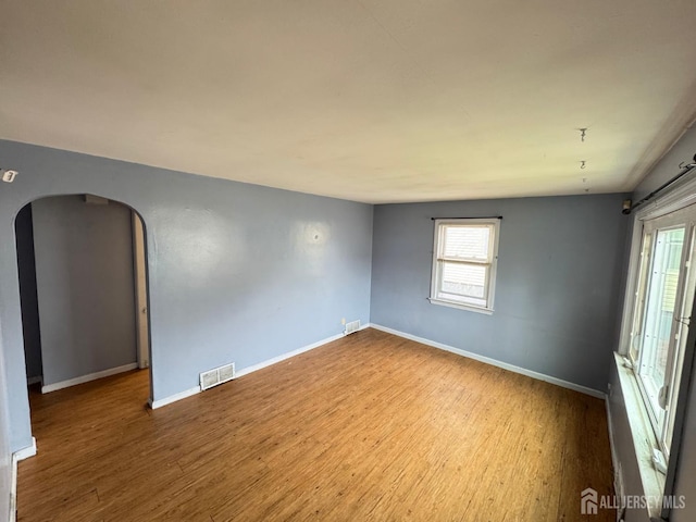 341 David St, South Amboy, NJ 08879 - empty room with plenty of natural light, wood finished floors, and arched walkways