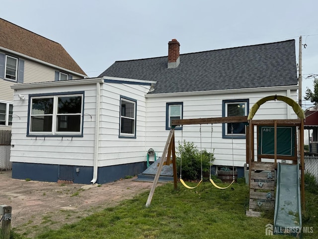 341 David St, South Amboy, NJ 08879 - rear view of property with a chimney, roof with shingles, entry steps, and a lawn