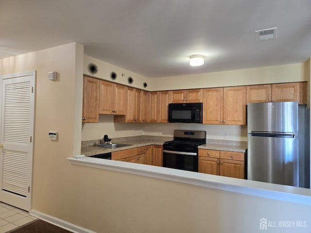 1338 Fernwood Ct, New Brunswick, NJ 08901 - kitchen featuring gas stove, freestanding refrigerator, black microwave, light tile patterned floors, and a sink