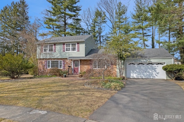 view of front facade with a front lawn, brick siding, driveway, and an attached garage