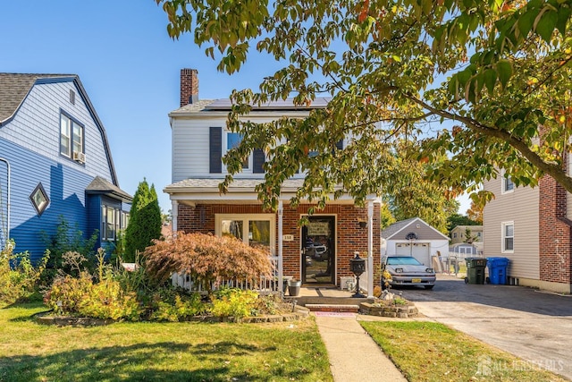 view of front of property with an outbuilding, a garage, and a front lawn