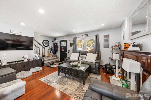 living room featuring wood-type flooring and a textured ceiling