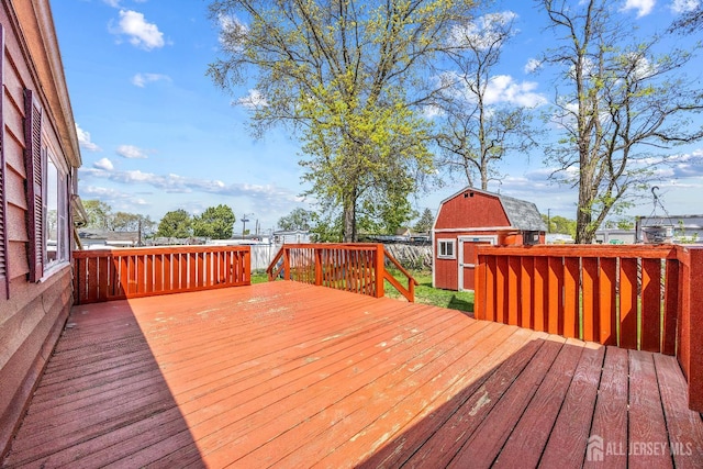 deck featuring a storage unit, an outdoor structure, and a fenced backyard