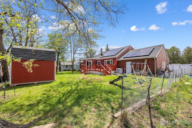 view of yard featuring a shed, an outdoor structure, a deck, and cooling unit