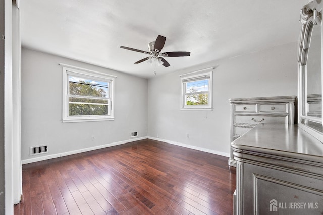 unfurnished room featuring ceiling fan, baseboards, and dark wood-style floors