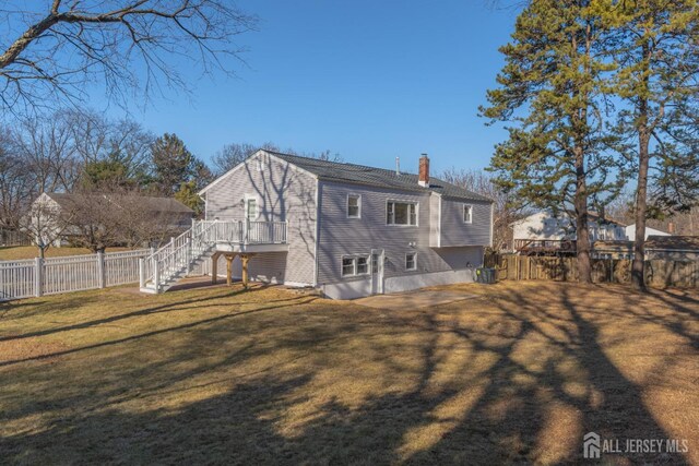 back of property featuring a yard and a wooden deck