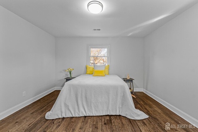 bedroom with dark hardwood / wood-style flooring