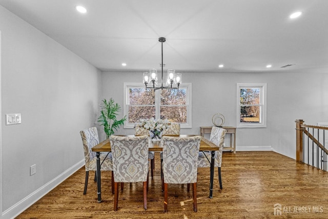 dining area with dark hardwood / wood-style floors and a chandelier