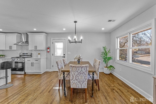 dining room with a chandelier and light hardwood / wood-style floors