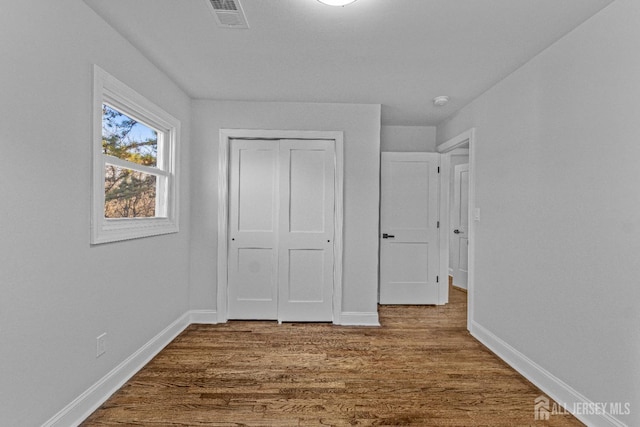 unfurnished bedroom with a closet and wood-type flooring