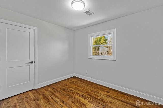 unfurnished room with wood-type flooring