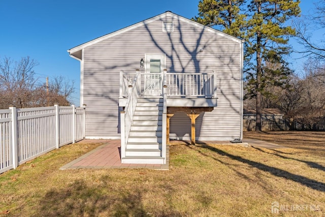 rear view of house with a lawn and a wooden deck