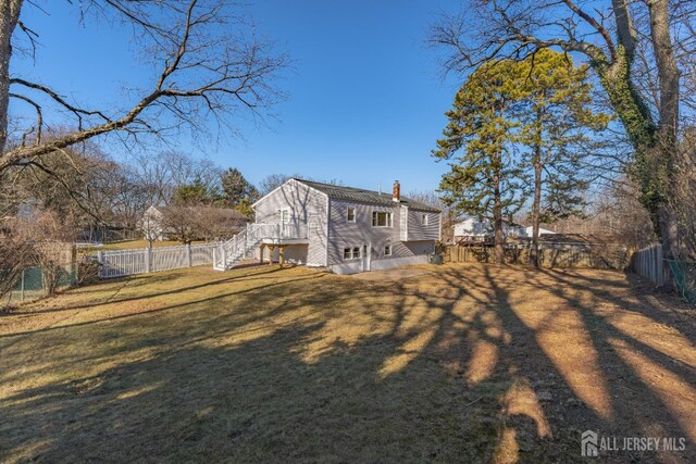 rear view of house featuring a yard and a wooden deck