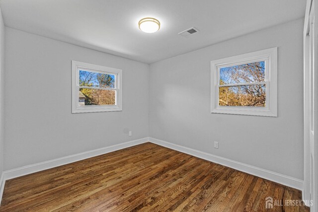 unfurnished room with hardwood / wood-style floors and a healthy amount of sunlight