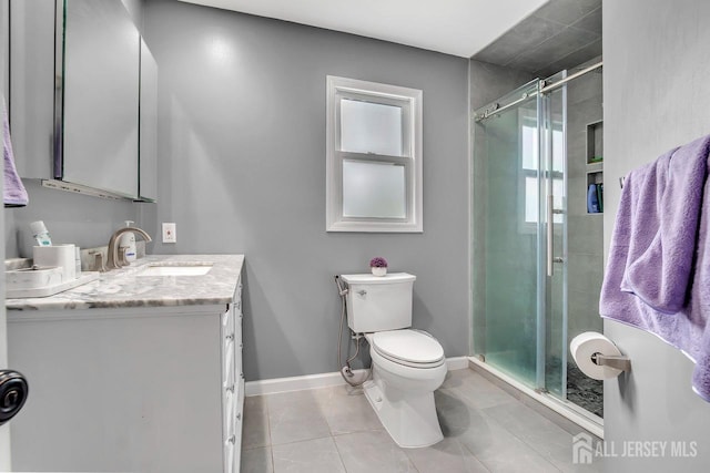 full bathroom with tile patterned flooring, vanity, toilet, baseboards, and a stall shower