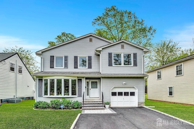 traditional-style house with a garage, aphalt driveway, a front yard, and cooling unit