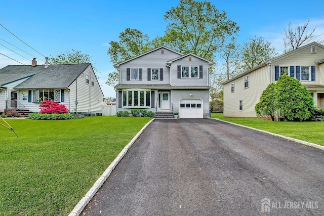 view of front of house featuring an attached garage, a front yard, and aphalt driveway