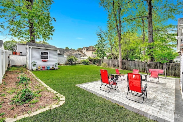 view of yard featuring a fenced backyard, an outbuilding, a patio area, and a shed