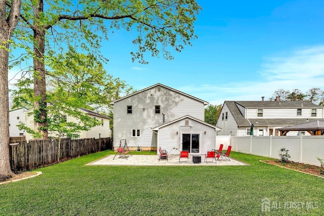 rear view of property with a lawn, a fenced backyard, and a patio area