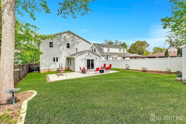 rear view of property featuring a fenced backyard, a patio, and a yard