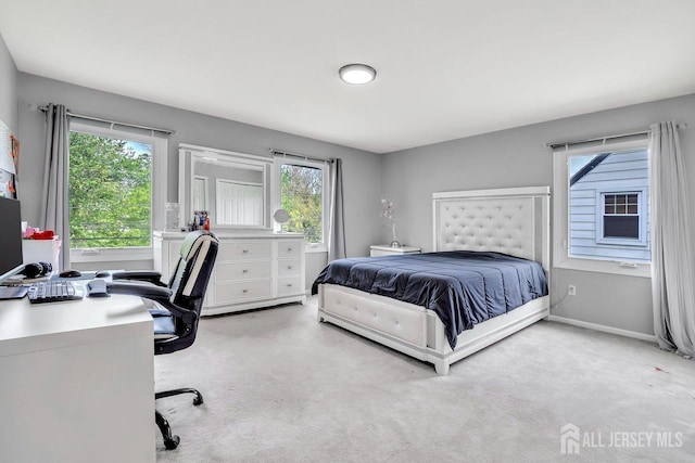 bedroom with carpet floors, baseboards, and multiple windows