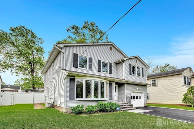 view of front of home with a garage, fence, a front yard, a gate, and driveway