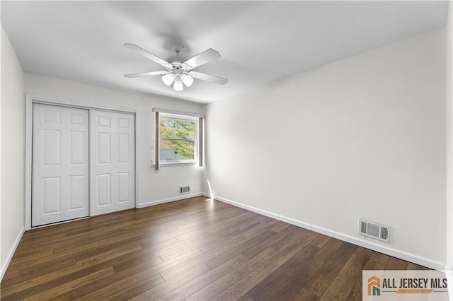 unfurnished bedroom with dark wood-style flooring, baseboards, a closet, and ceiling fan