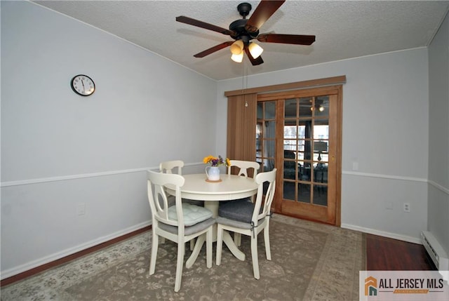 176 Rossmoor Dr Unit C, Monroe, NJ 08831 - dining room featuring a ceiling fan, a textured ceiling, a baseboard heating unit, wood finished floors, and baseboards
