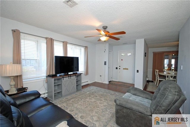 176 Rossmoor Dr Unit C, Monroe, NJ 08831 - living area featuring baseboard heating, a ceiling fan, a textured ceiling, and wood finished floors