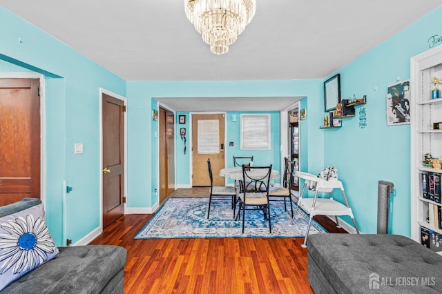 dining space featuring an inviting chandelier, wood finished floors, and baseboards