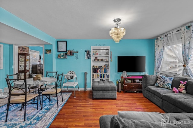 living room with wood finished floors, baseboards, and a chandelier