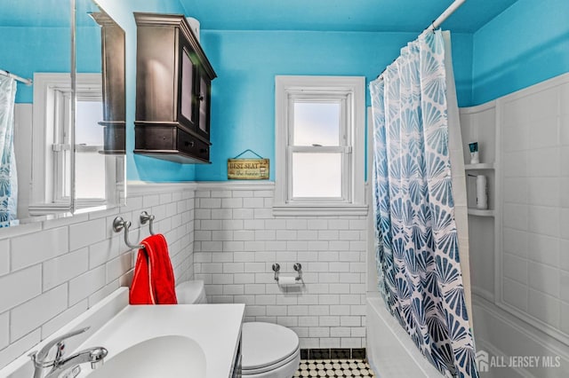 bathroom featuring vanity, shower / bath combo, tile patterned flooring, tile walls, and toilet