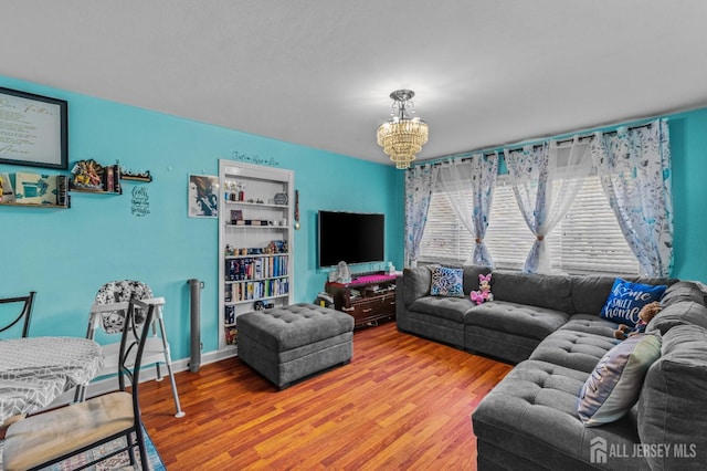 living room with a chandelier, baseboards, and wood finished floors