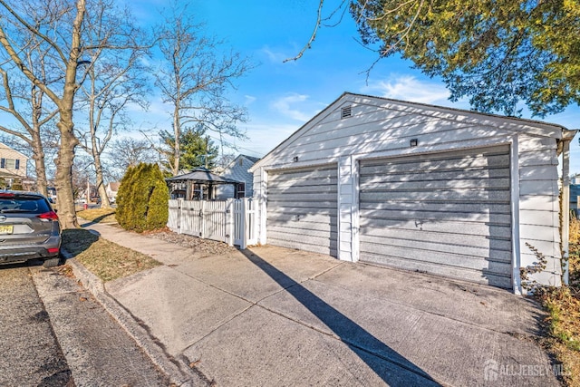 detached garage featuring fence