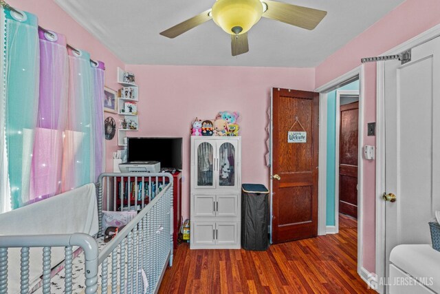 bedroom with a ceiling fan and dark wood-style flooring