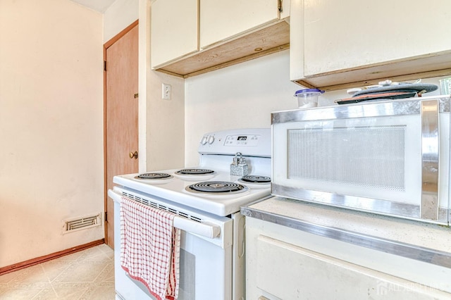 kitchen with white electric stove, light flooring, baseboards, and light countertops