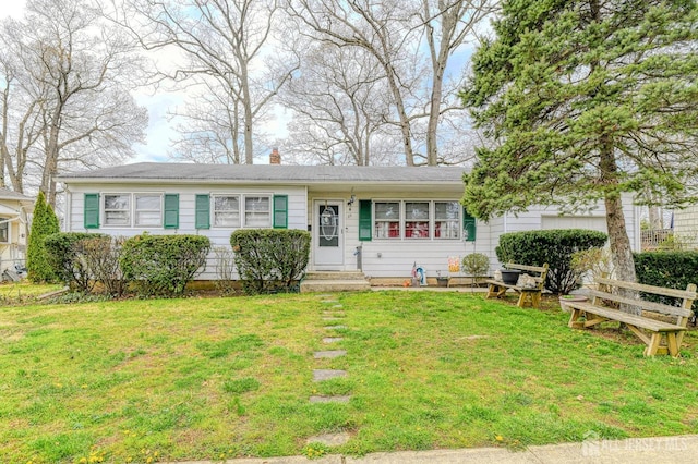 view of front of house with a front yard, a chimney, and entry steps