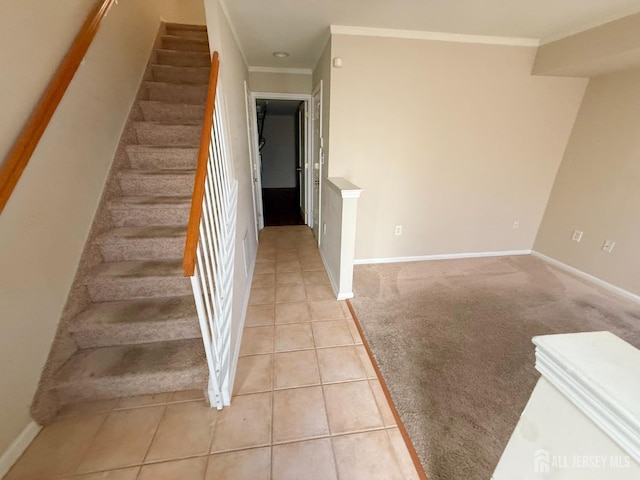 stairway featuring ornamental molding and tile patterned floors