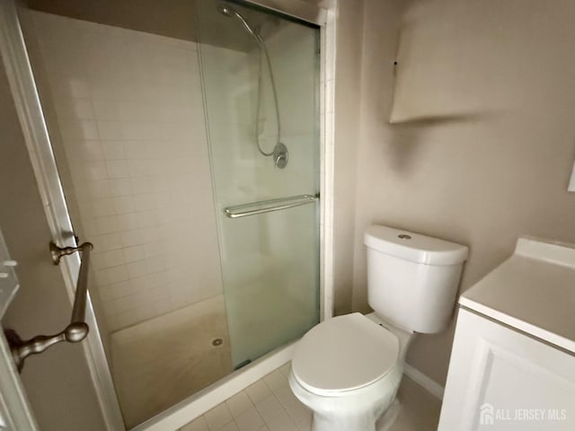 bathroom with an enclosed shower, tile patterned floors, and toilet