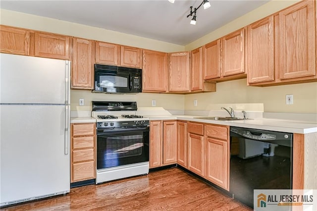 kitchen with wood-type flooring, sink, light brown cabinets, and black appliances