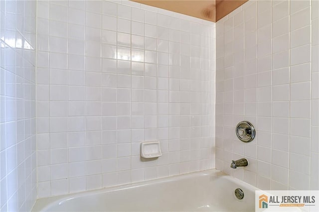 bathroom featuring tiled shower / bath