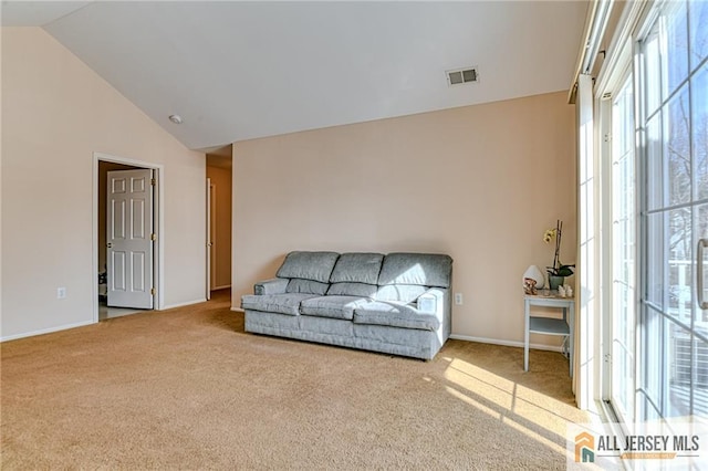 sitting room featuring light colored carpet and high vaulted ceiling