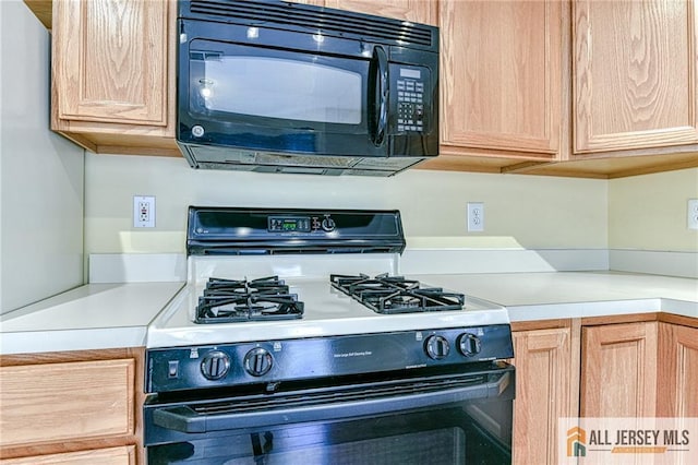 kitchen with white gas range oven and light brown cabinets