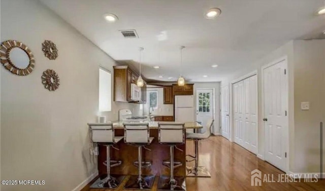 106 Manalapan Rd, Spotswood, NJ 08884 - kitchen featuring white appliances, a peninsula, light wood-style floors, hanging light fixtures, and recessed lighting